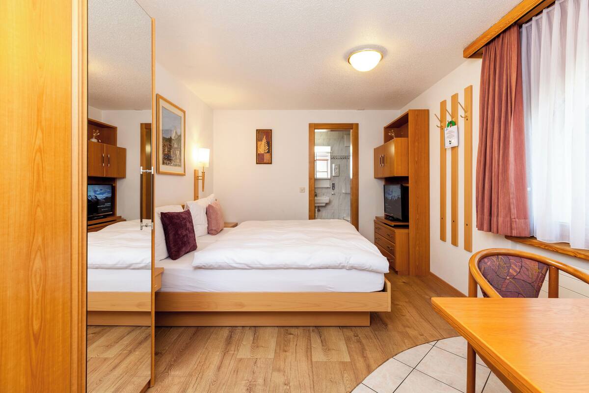 Ropa de cama hipoalergénica y caja de seguridad en la habitación 