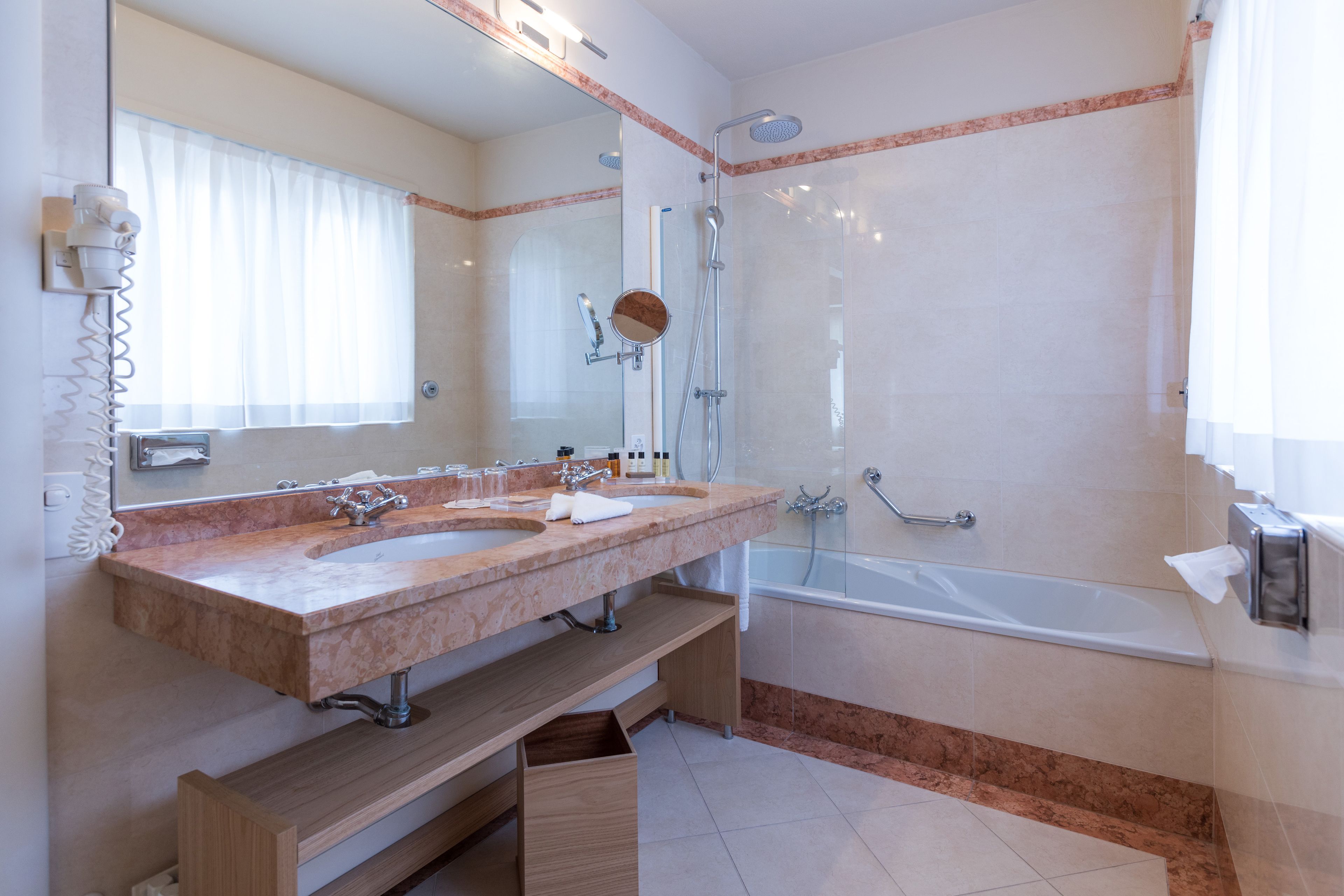 Ein Badezimmer mit zwei Waschbecken, einer Dusche und einer Badewanne.