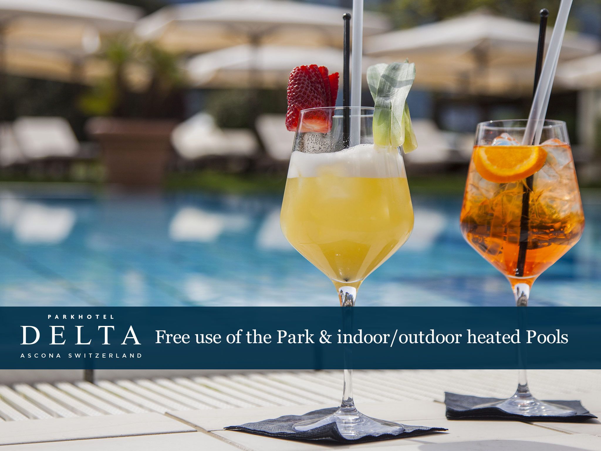 Two cocktails by a poolside with a sign for Parkhotel Delta offering free use of heated pools.