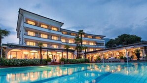 A multi-story hotel with a swimming pool in the foreground.