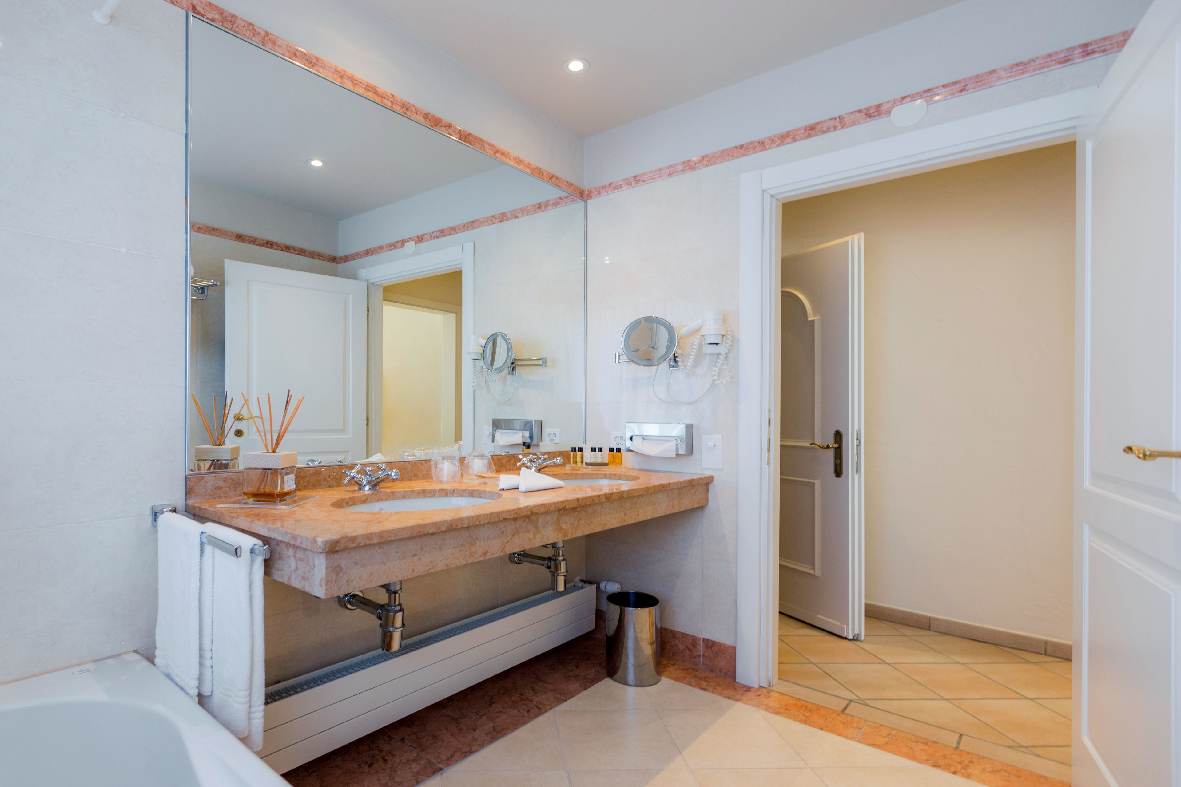 A bathroom with two sinks, a large mirror, and a shower.