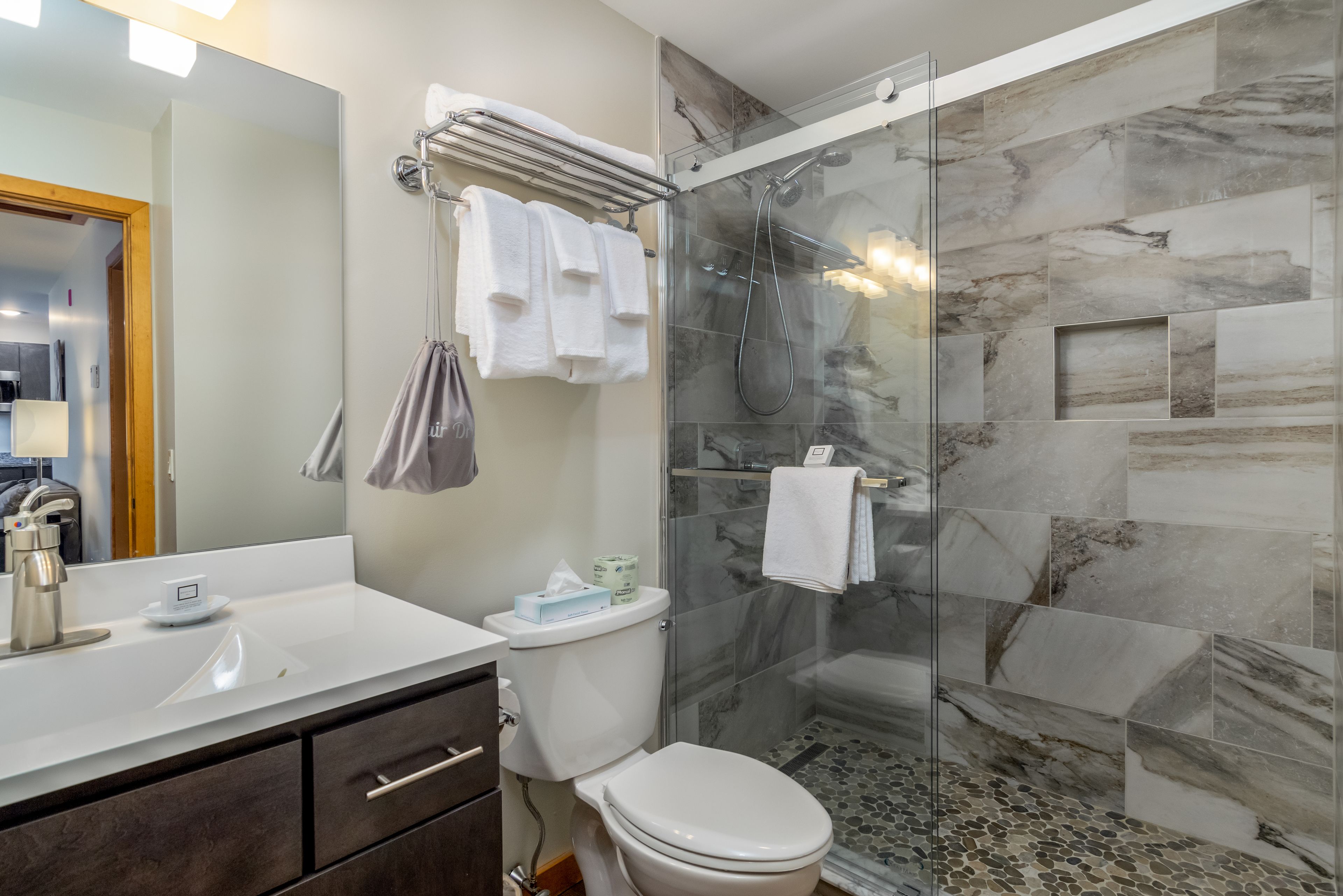 Une salle de bain moderne avec une douche à parois de verre, un lavabo blanc et des toilettes.