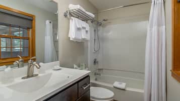 Un baño con lavamanos, inodoro y ducha.