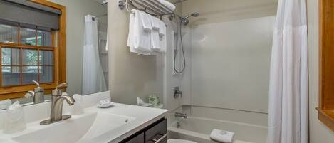 Un baño con lavamanos, inodoro y ducha.
