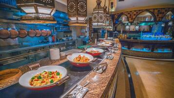 A buffet setup with various dishes, serving utensils, and hanging lanterns.