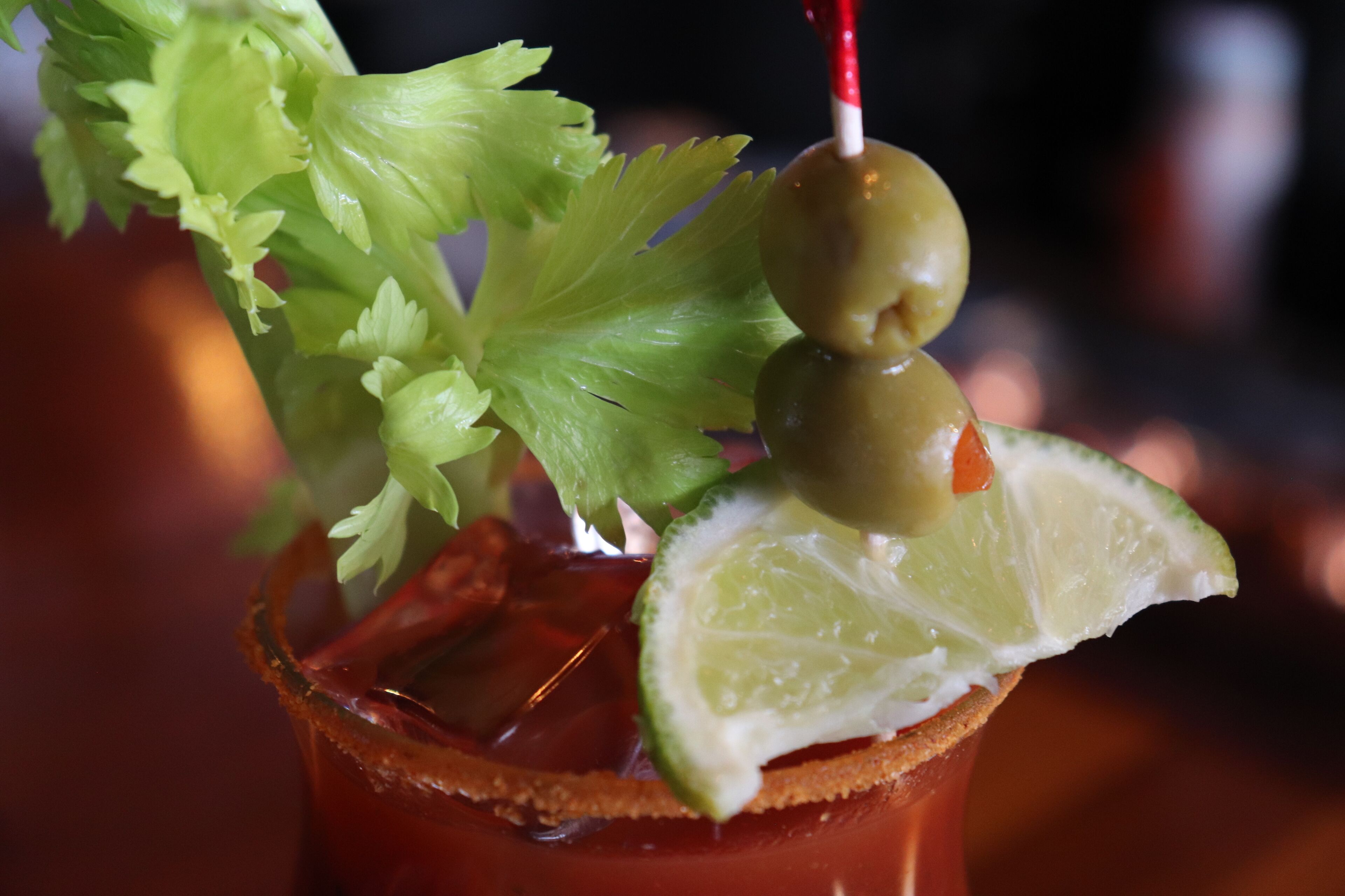 Un cocktail Bloody Mary, garni de céleri, d’olives et d’un quartier de citron vert.