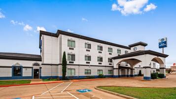 Stunning hotel building with a symmetrical facade and central entrance, set amidst a well-manicured lawn.