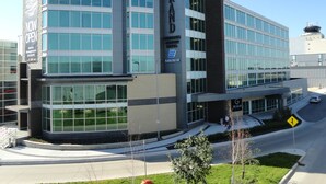 A modern hotel building with large windows, a prominent 'GRAND' sign, and a 'NOW OPEN' banner. - The Grand Winnipeg Airport Hotel by Lakeview (Winnipeg)