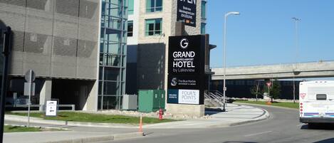 Un moderno edificio de hotel con un letrero llamativo que anuncia sus habitaciones disponibles.