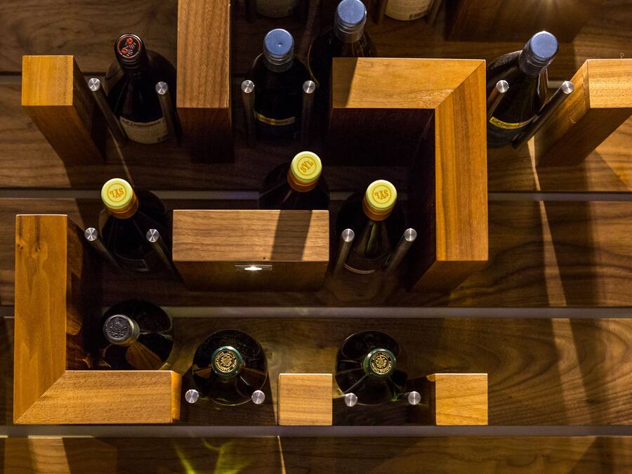 A wooden wine rack with bottles arranged in a grid pattern.