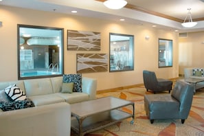 A hotel lobby with a sofa, armchairs, a coffee table, and artwork on the walls. - Comfort Inn & Suites Grand Forks near Alerus Center (Grand Forks)