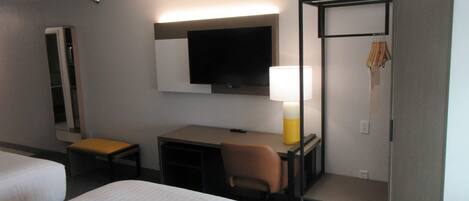 Une chambre d’hôtel équipée d’un lit, d’un bureau, d’une chaise, d’une télévision et d’une armoire.