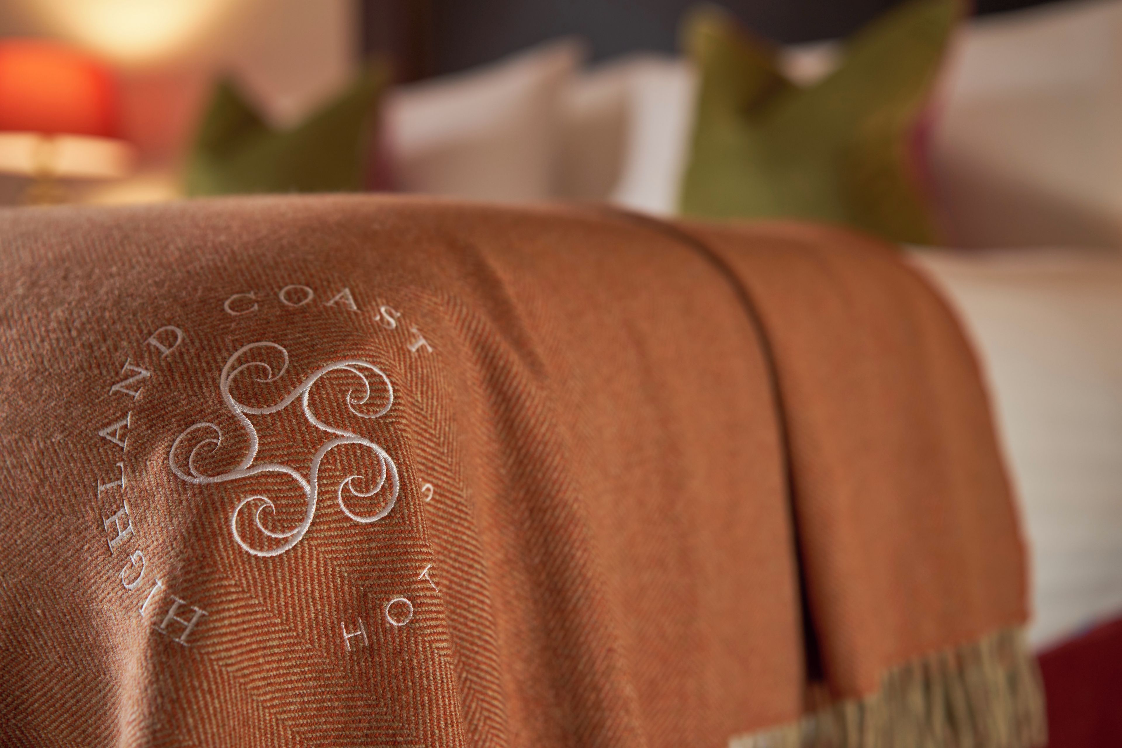 Un gros plan d’un tissu marron orné de motifs brodés et d’un bouton.