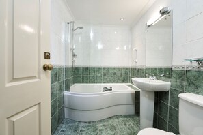A modern bathroom with a freestanding bathtub, a sink, and a toilet. - Lochardil House Hotel (Inverness)