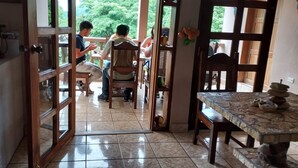 An open doorway leading to a dining area with a tiled floor and a table with a stone top. - Hotel La Escalinata (Copan Ruinas)