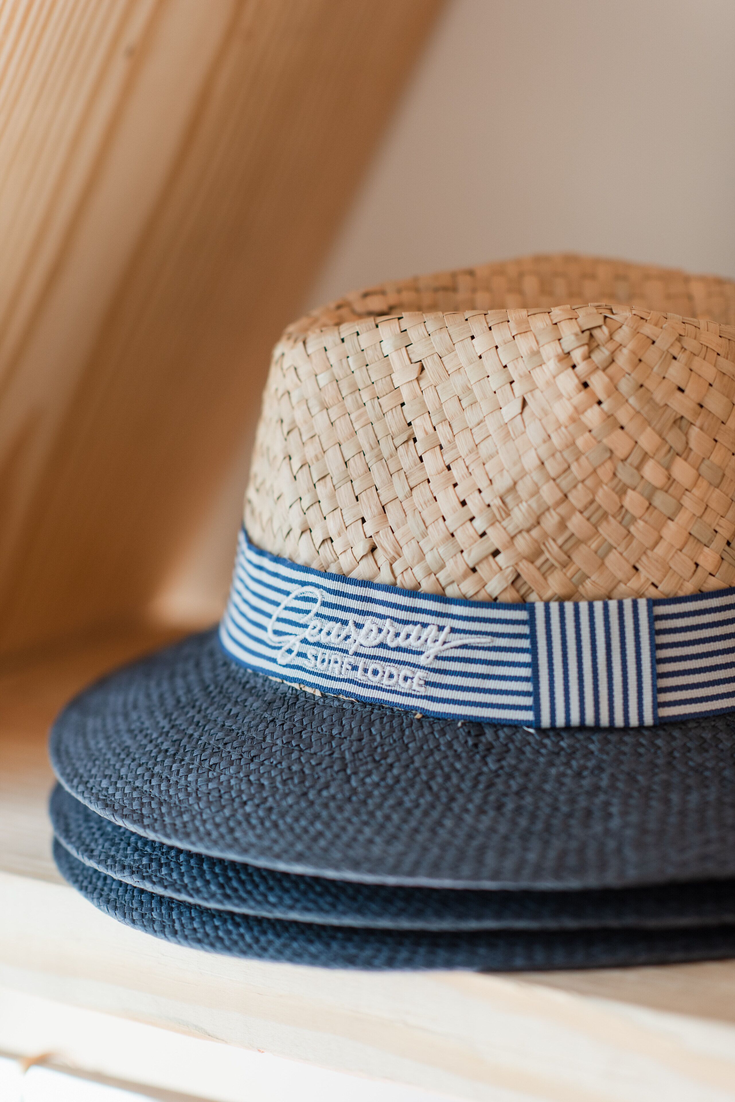 A woven straw hat with a blue and white striped band.