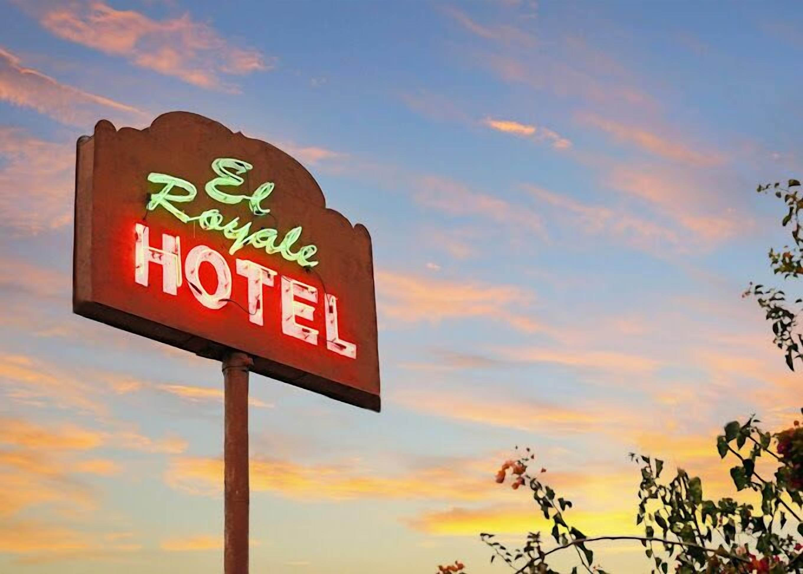 Ein Leuchtreklame des El Royale Hotels vor einer Sonnenuntergangs-Kulisse.