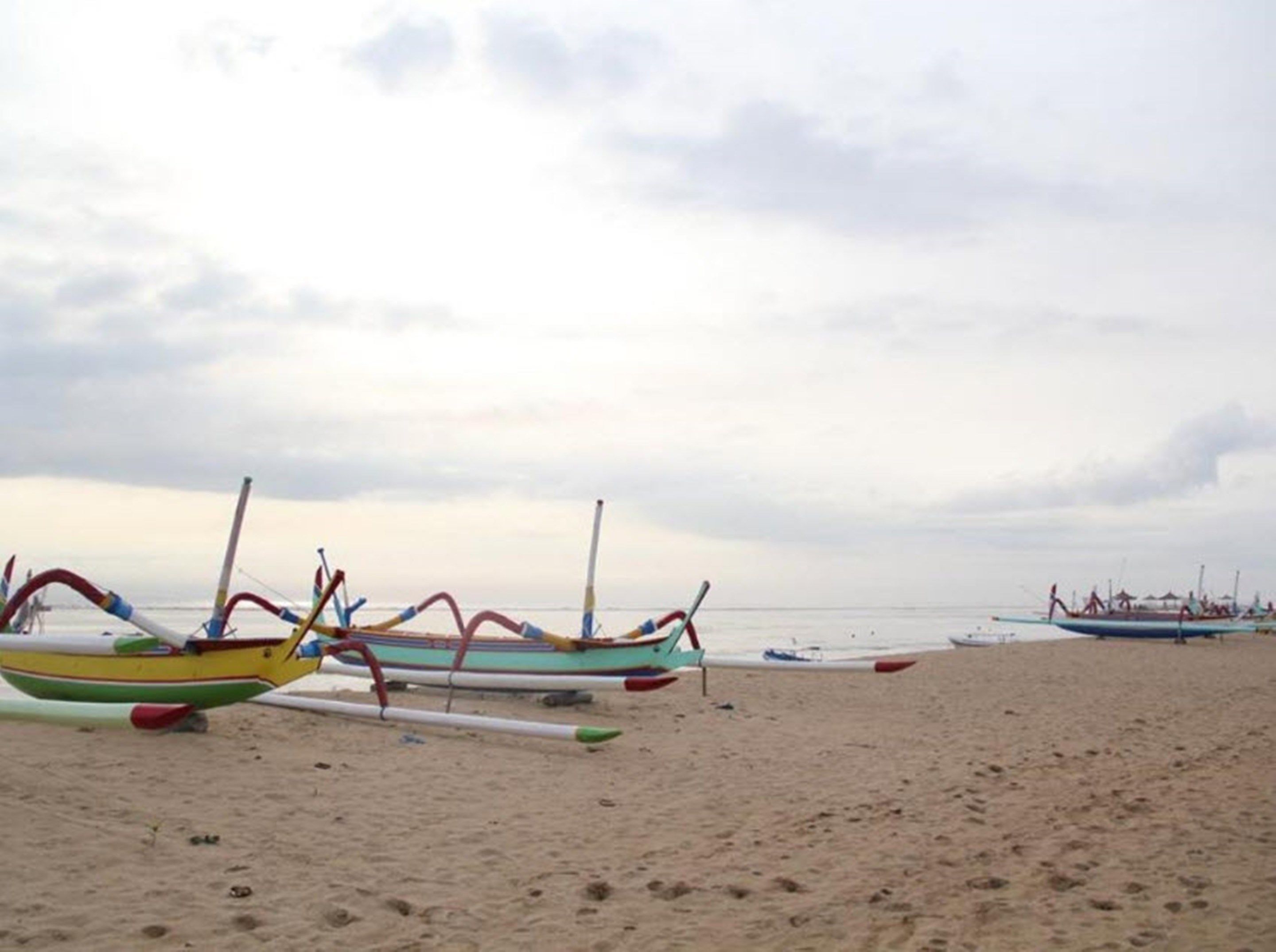 A beach with several colorful boats parked on the sand.