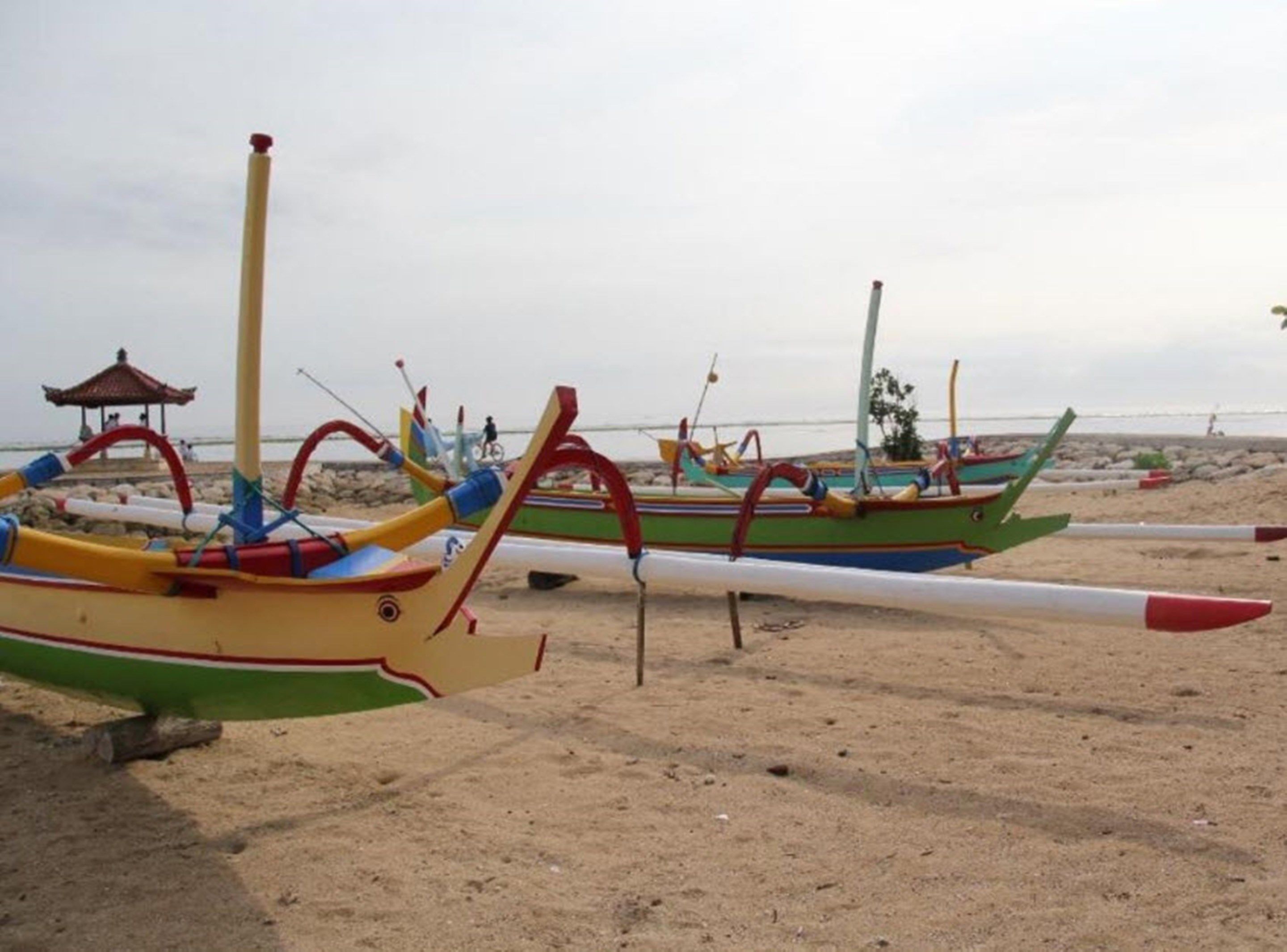 A row of colorful boats on a sandy beach.