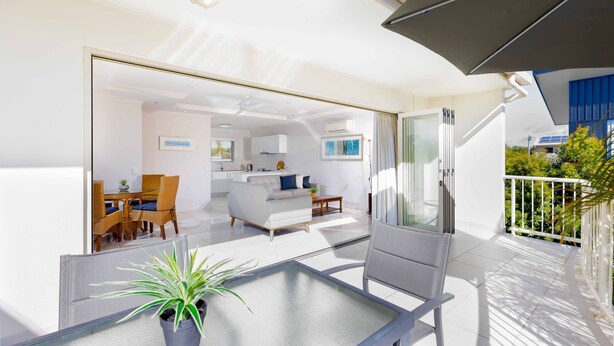 A modern apartment with a balcony, a dining area, and a kitchen.