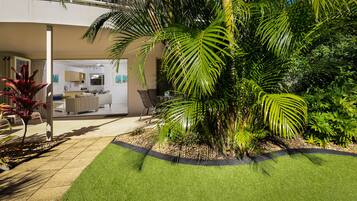 A modern house with a patio area, a dining area, and a kitchen visible through an open door.