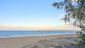 On the beach, white sand, sun loungers, beach towels