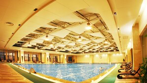 An indoor swimming pool with a high ceiling and a geometric metal framework. - Grand Barony Zhoushan (Zhoushan)