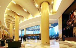 A spacious lobby with high ceilings, large columns, and a modern design. - Grand Barony Zhoushan (Zhoushan)