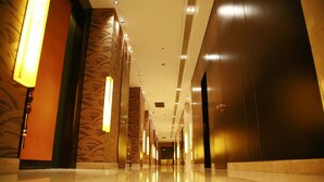 A long, polished hallway with a reflective floor, leading to a dark elevator area. - Grand Barony Zhoushan (Zhoushan)