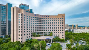A large hotel with a modern design, featuring a prominent entrance and multiple floors. - Grand Barony Zhoushan (Zhoushan)