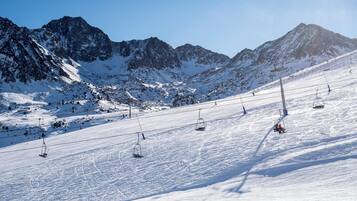 A snowy mountain slope with ski lifts and a clear sky.