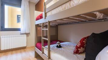 A bunk bed room with a window, a radiator, and a panda plush toy.