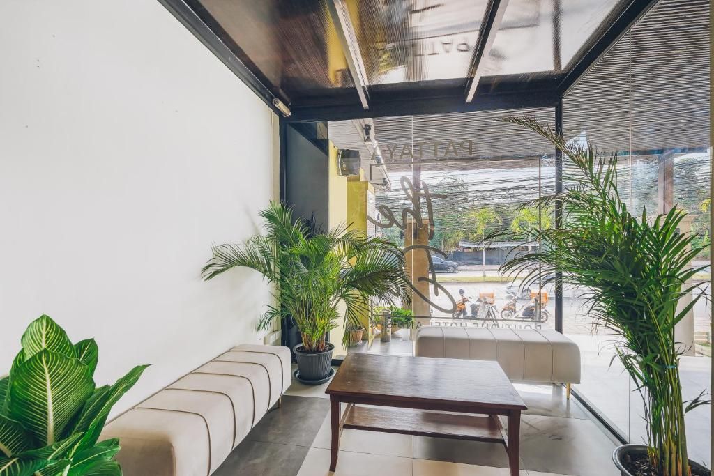 A modern interior with a sofa, a table, and potted plants.