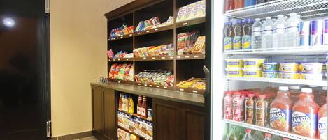 Un supermercado con estantes repletos de diversos productos alimenticios y bebidas.