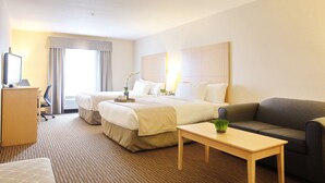 Ett hotellrum med en stor säng, ett skrivbord, en soffa och ett litet bord.