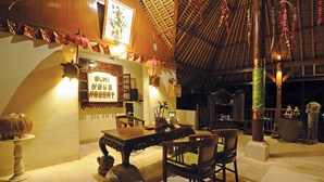 A traditional wooden interior with a dining area, a sign reading "BUMI UBUD RESORT," and a thatched roof. - Bumi Ubud Resort (Ubud)