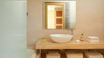Une salle de bain avec un grand lavabo blanc, un miroir et un porte-serviettes.