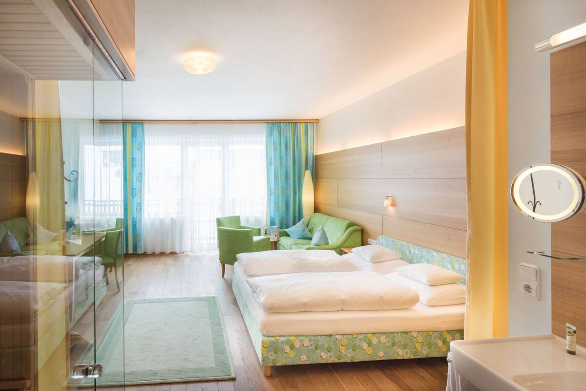 A hotel room with a bed, a desk, a chair, and a bathroom.