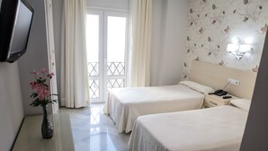 A hotel room with two beds, a bedside table, a TV, and a window with curtains. - Hostal Chaikana (El Puerto de Santa Maria)
