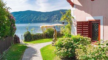 Ein Weg, der zu einem Gebäude mit Blick auf einen See und Berge führt.
