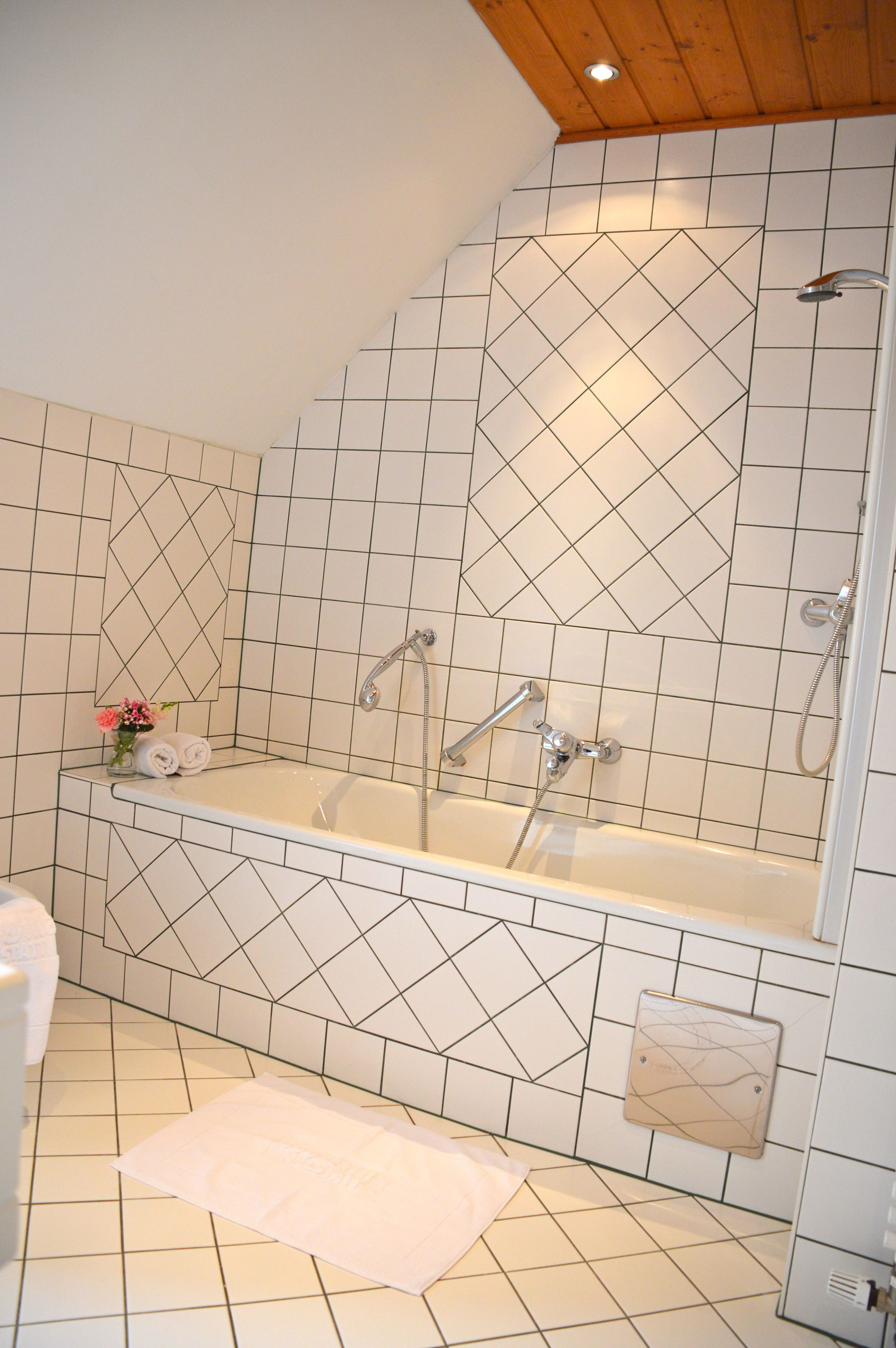 Un baño con una bañera independiente, ducha y perchero.