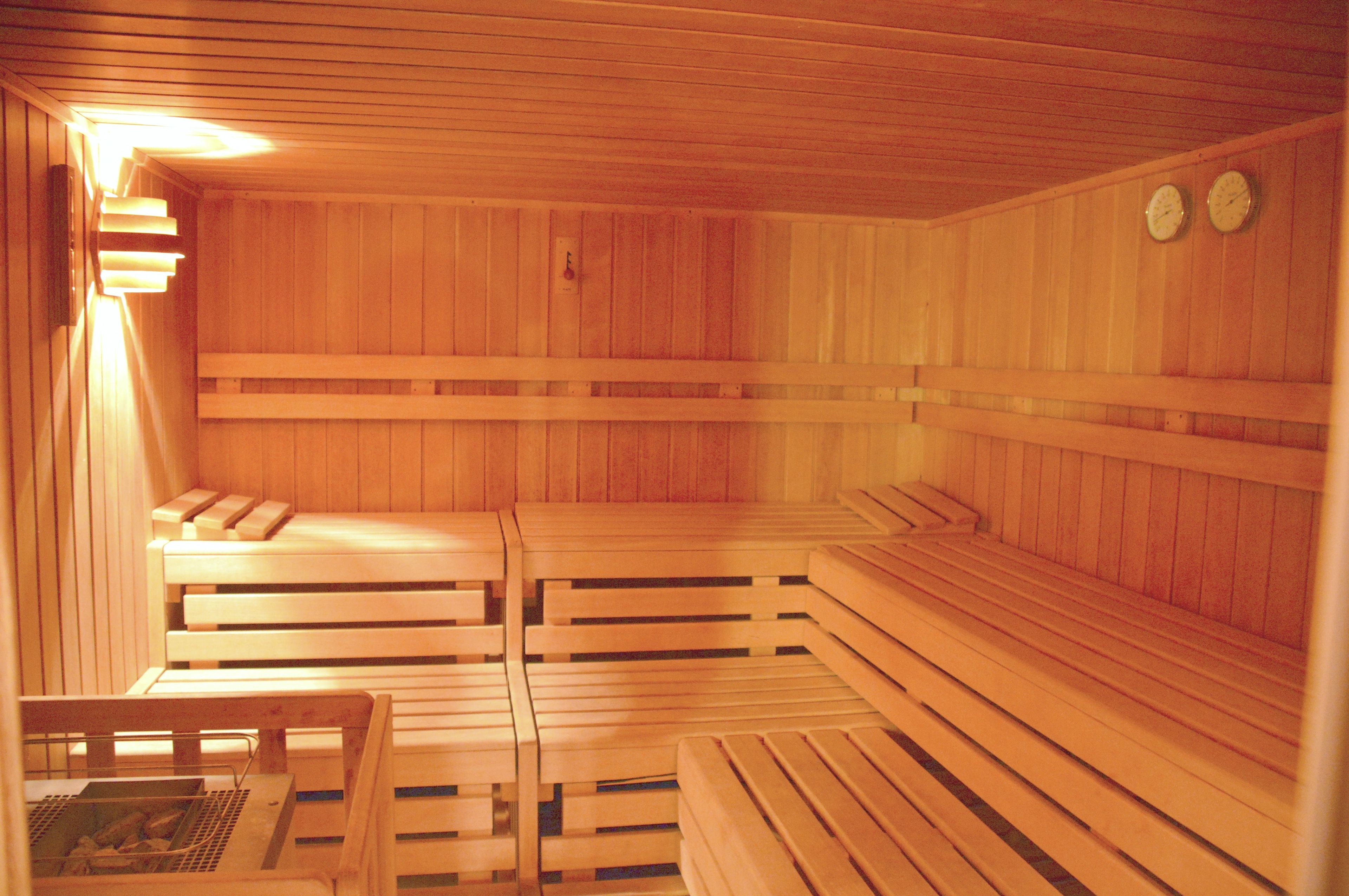 Una sauna de madera con bancos y una pequeña mesa.