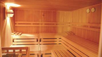Eine Holzzimmer-Sauna mit Bänken und einem kleinen Tisch.
