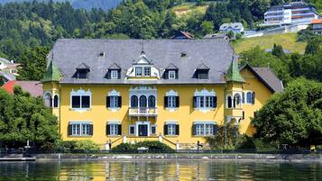 Un bâtiment jaune doté d’un balcon et offrant une vue sur un lac.