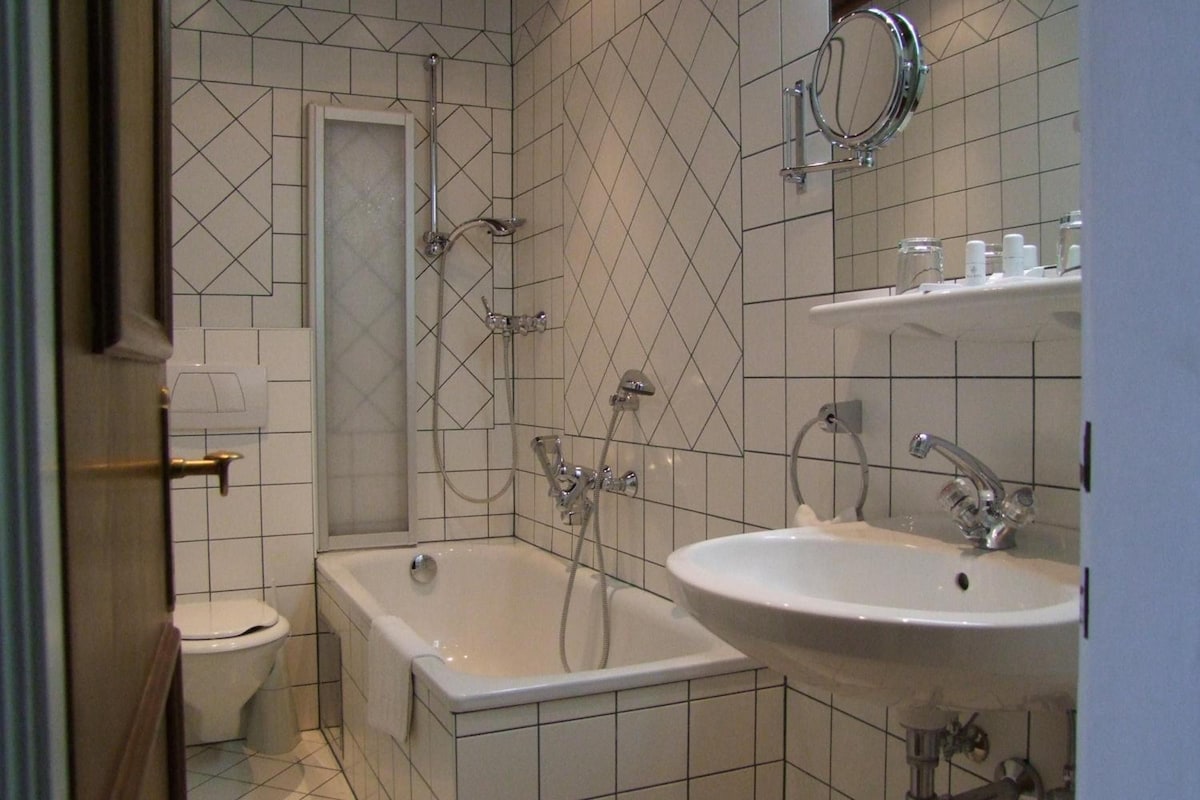 A bathroom with a bathtub, a toilet, and a sink.