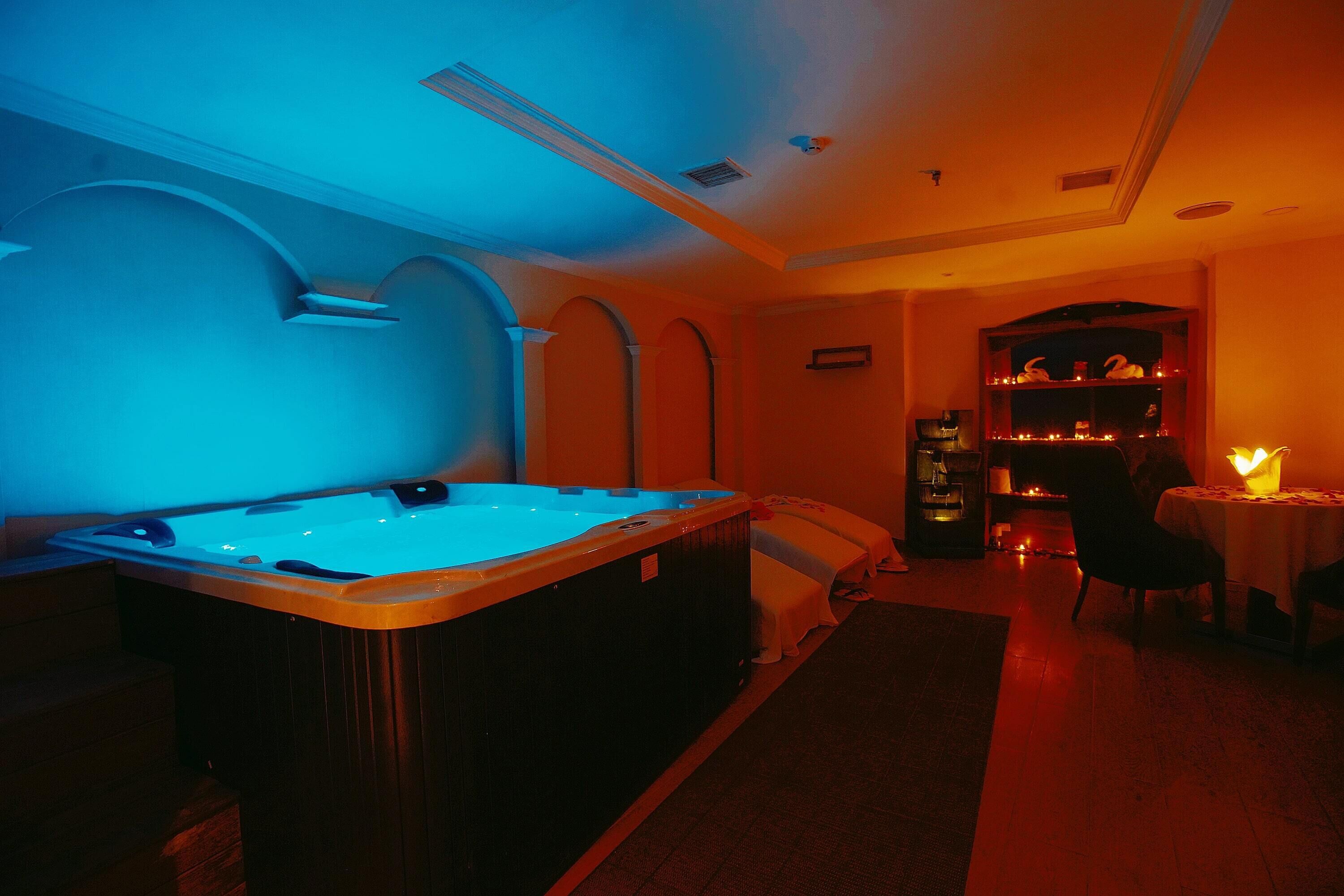 Une pièce dotée d’un jacuzzi, d’une cheminée et d’un coin repas.