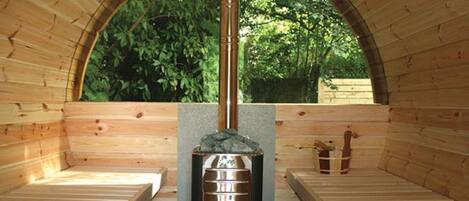 A sauna with a wooden interior, a central heating unit, and benches.