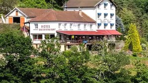 A hotel with a restaurant, surrounded by lush greenery. - Hôtel Restaurant Belle Vue (Les Ancizes-Comps)