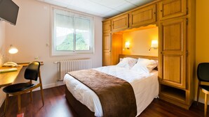 A bedroom with a bed, wooden wardrobe, desk, chair, and a television. - Hôtel Restaurant Belle Vue (Les Ancizes-Comps)