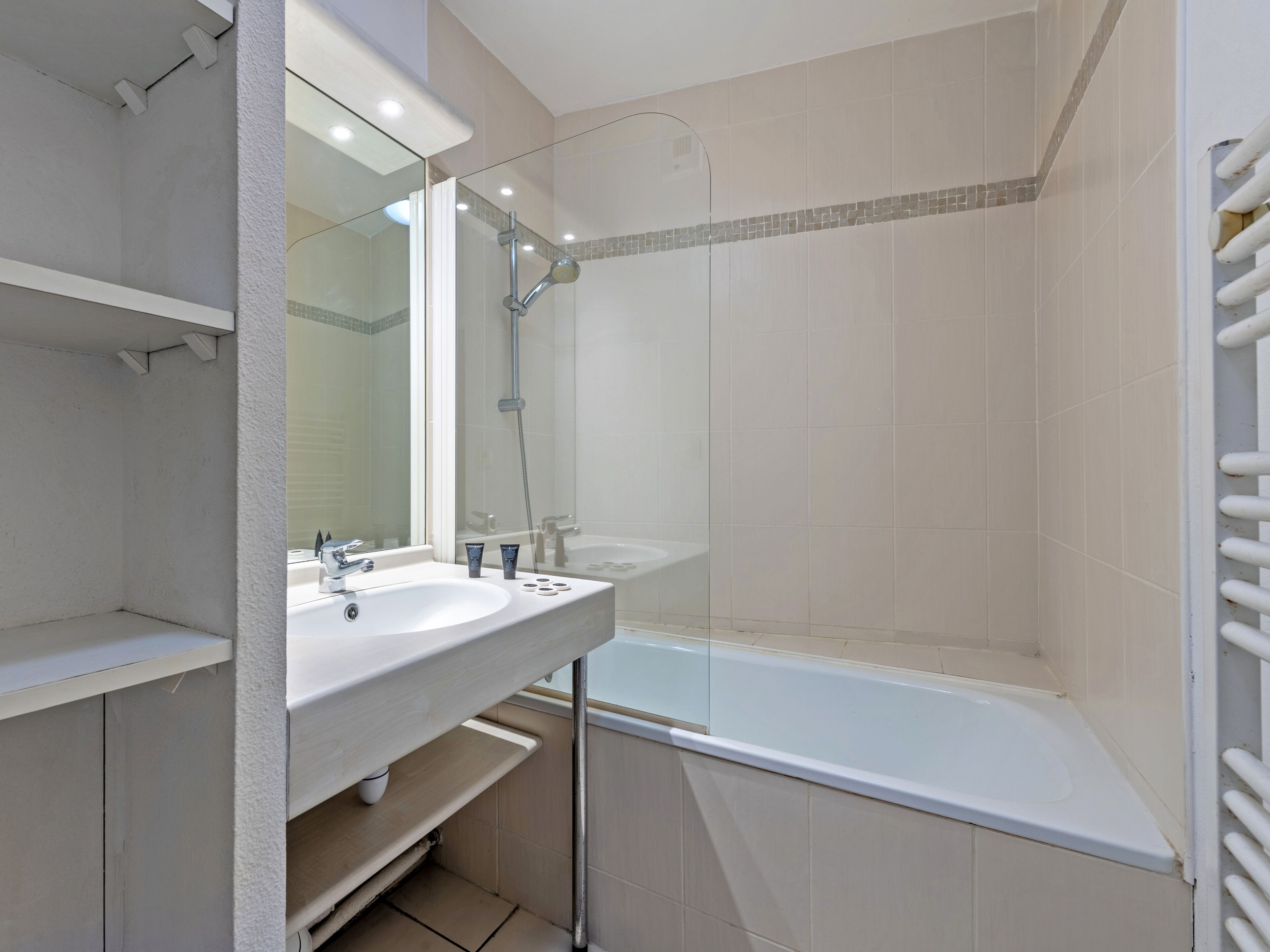 Une salle de bain moderne avec un lavabo blanc, un miroir et une douche.